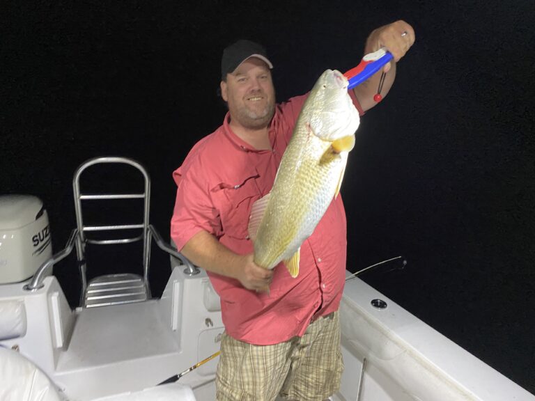 Man holding a red fish by night | Thermocline Fishing Charters | Gulf of Mexico Offshore Deep Sea Fishing Trips | St Pete Florida
