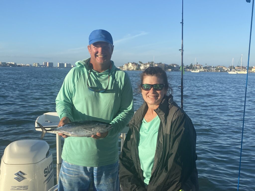 Man and woman holding a fish St. Pete offshore fishing charters