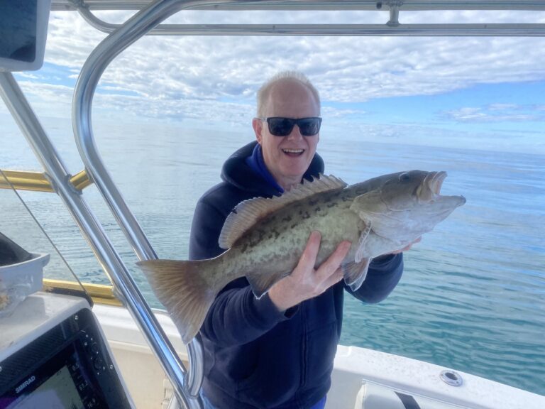 Thermocline Fishing Charters Man holding large salt water fish on boat