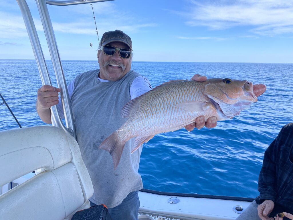 Man smiling holding Red Snapper - St. Pete offshore fishing charters